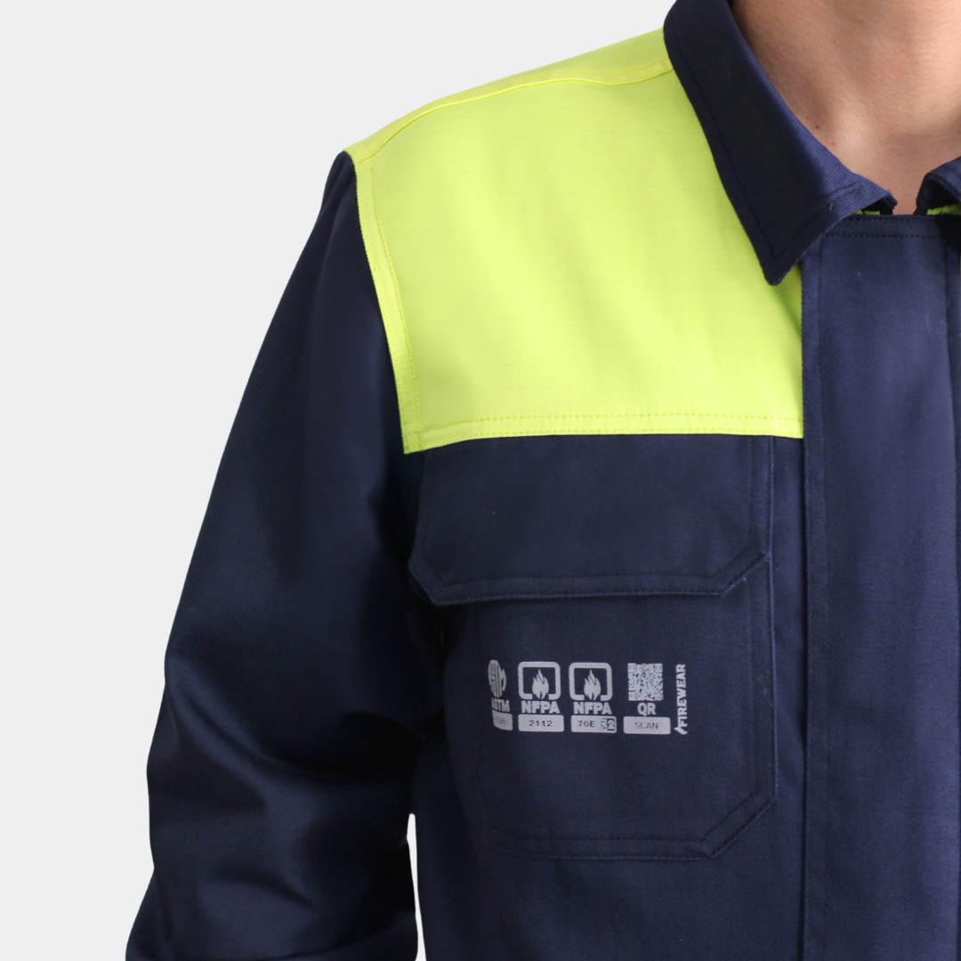 Detalle de bolsillo de pecho de overol ignífugo FIREWEAR® bicolor azul y amarillo para hombre.
